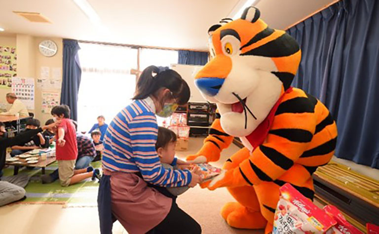 トニー・ザ・タイガーからシリアルを受け取る子ども トニー・ザ・タイガーからシリアルを受け取る子ども